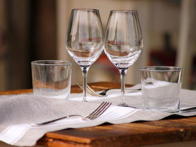 drinking glass, cutlery on eating table